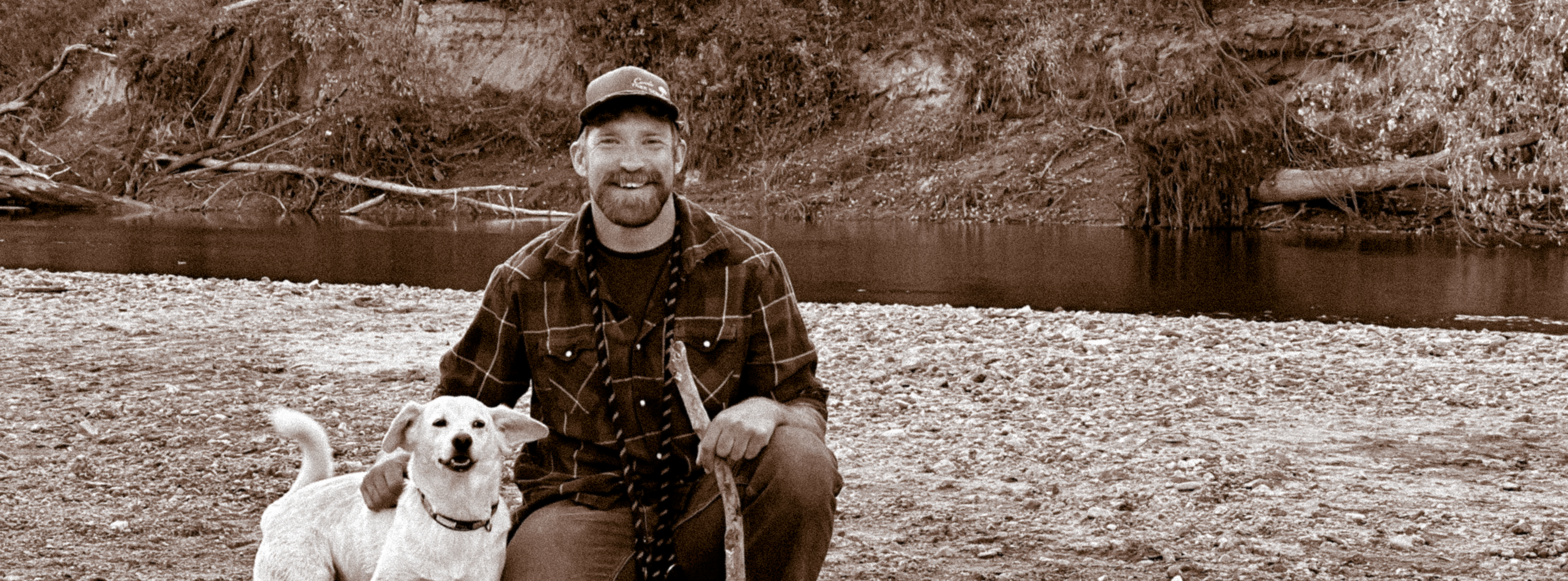 Mike Harinen with his dog, Lumi, on a river bank